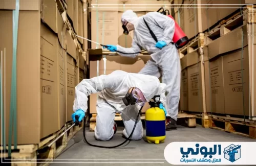 مكافحة حشرات المنازل بالرياض 0500805875 البوني فريق مكافحة يرتدي بدلات وقائية داخل مخزن بضائع.