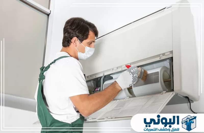 عامل ينفذ تنظيف مكيفات ضمن خدمة تنظيف مكيفات بالقصيم.