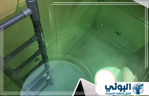 تنظيف الخزانات الخرسانية بالدمام 0500805875 شركة البوني خزان مياه أخضر ممتلئ بمياه صافية، تظهر فيه أنابيب التمديد وسلم داخلي للتنظيف والصيانة