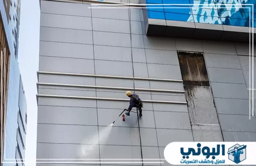 شركة تنظيف عمائر بالرياض 0500805875 شركة البوني تنظيف واجهة مبنى مرتفعة بالحبال يوضح القدرة على العمل في الارتفاعات.